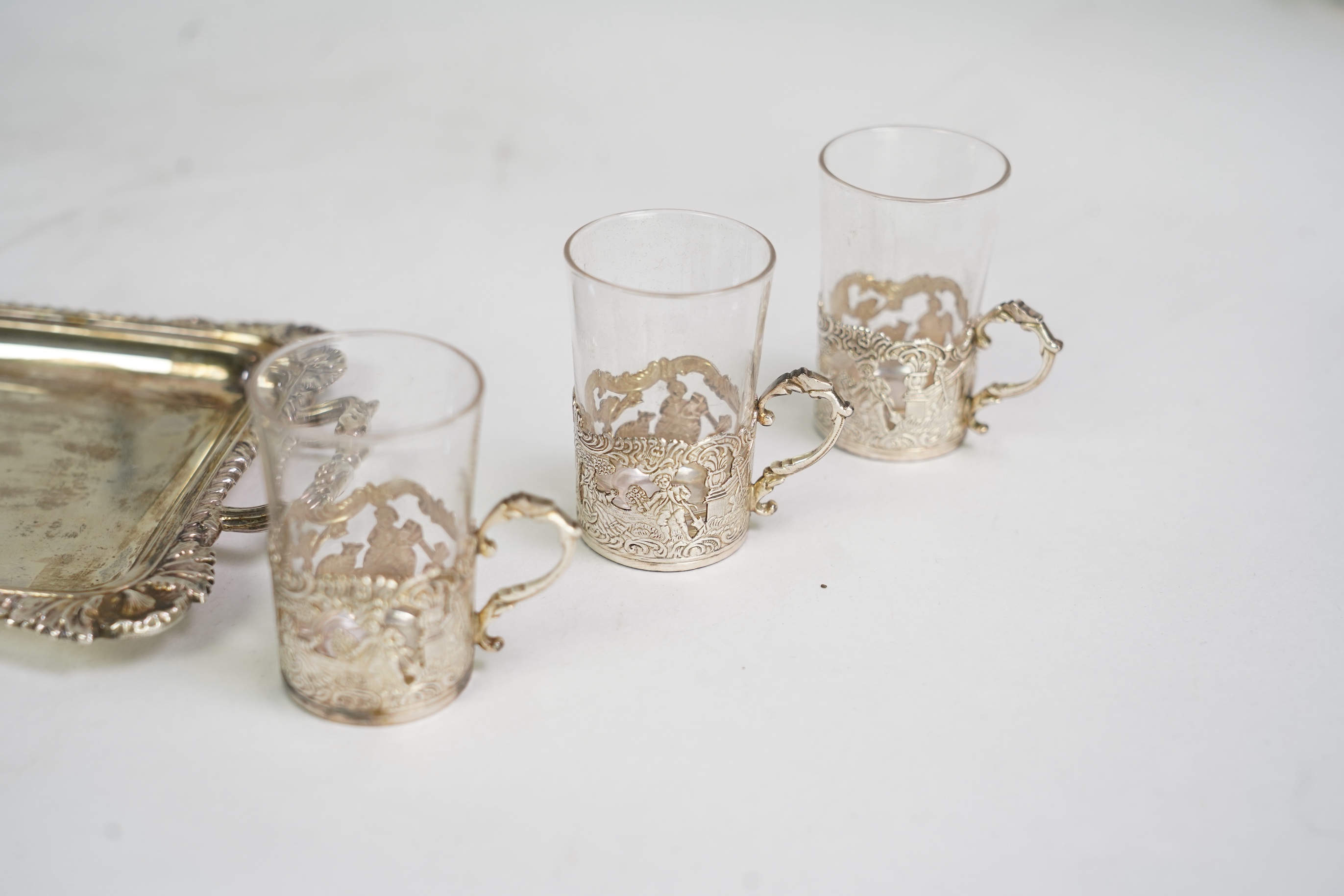 An Edwardian cased silver small two handled serving tray with six matching silver mounted glass liqueur tots, by Atkin Brothers